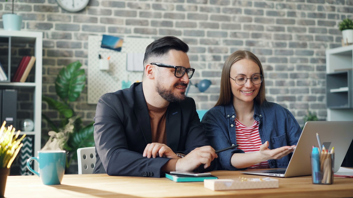Couple discussing finances with laptop open