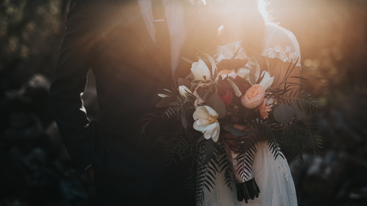 Couple planning their wedding budget together at a table with a laptop and notebook